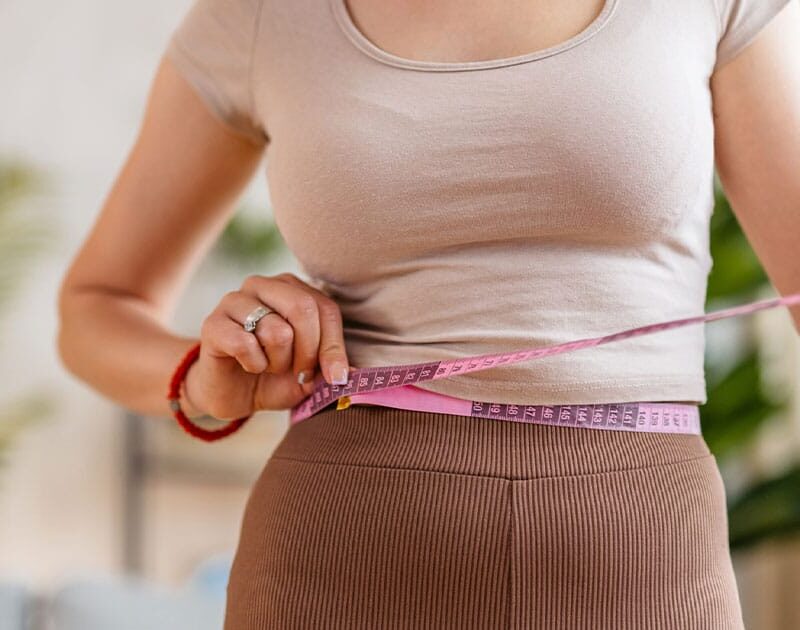 woman measuring her waist after starting compounded semaglutide in Ashburn, VA